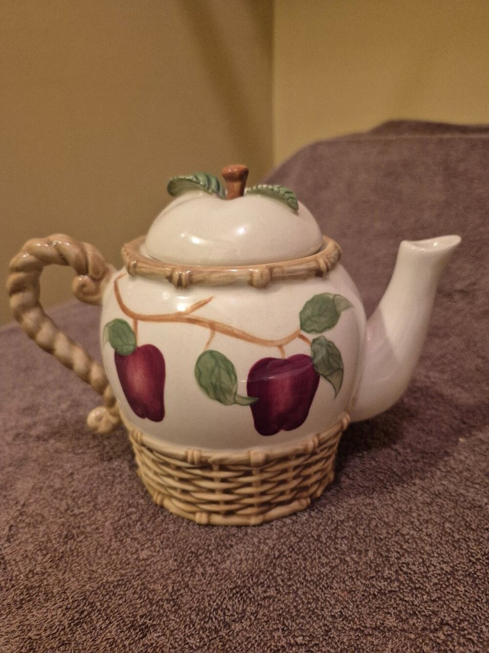 VINTAGE CERAMIC TEAPOT TOP PAINTED WITH APPLES AND WOVEN-STYLE BASKET BASE